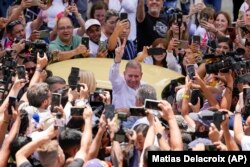 El candidato presidencial de la oposición, Edmundo González, hace un signo de victoria cuando llega a votar en las elecciones presidenciales en Caracas, Venezuela, el domingo 28 de julio de 2024. (Foto AP/Matías Delacroix)