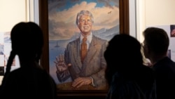 Visitantes pasan frente a un retrato del expresidente Jimmy Carter en el centro que lleva su nombre, en Atlanta. (AP/Ben Gray)