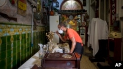 Un empleado del restaurante privado San Cristóbal de La Habana pinta un candelabro. (AP/Ismael Francisco/Archivo)