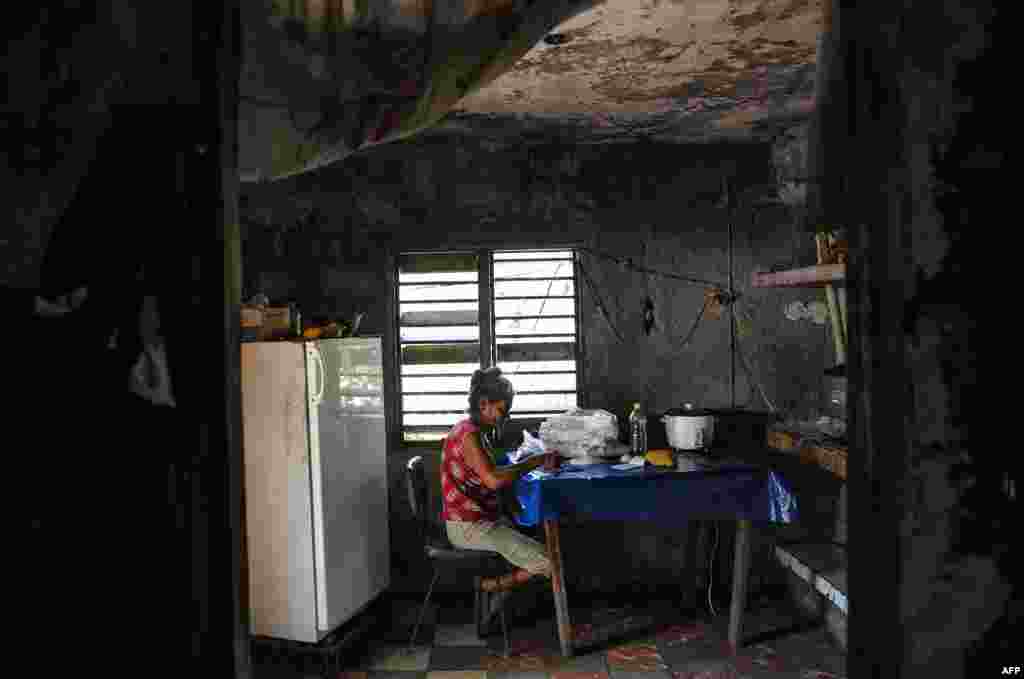 Una señora escoge arroz en su casa en El Caney, Santiago de Cuba el 21 de junio de 2017.&nbsp;YAMIL LAGE / AFP