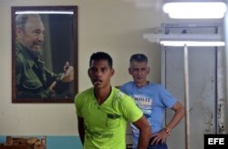 Dos hombres junto a un retrato del fallecido líder cubano Fidel Castro en La Habana (Cuba).