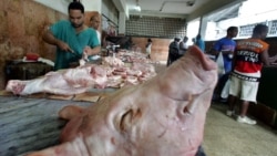 Un carnicero vende carne de cerdo en un mercado de La Habana. Los alimentos alcanzan precios prohibitivos para la mayoría de los cubanos. (AFP/Rodrigo Arangua/Archivo)