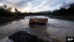 Un camión atraviesa un río crecido por las fuertes lluvias provocadas por el huracán Oscar en Guantánamo.