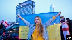 Una mujer sostiene una bandera nacional ucraniana mientras participa en una manifestación en apoyo de Ucrania, en el centro de Tbilisi, Georgia.