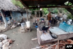 Un cubano cocina en un fogón de leña en una de las casas dañadas por el huracán Oscar, en Guantánamo.